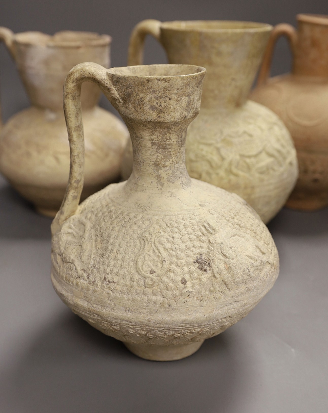 A selection of four Islamic terracotta jugs, Middle Eastern, possibly 12th century AD, The tallest 25 cm